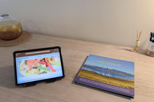 a tablet sitting on a table next to a book at The Remarkable in Hamilton
