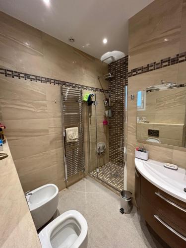 une salle de bain avec une douche, des toilettes et un lavabo dans l'établissement Vaste 2 pièces raffiné vue mer MENTON CENTRE, à Menton