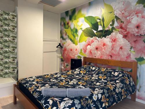 - une chambre avec un lit orné d'une fresque florale dans l'établissement Sky World Cozy Home, à Auckland