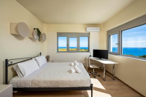 a bedroom with a bed and a desk with a computer at Villa Zafira - Seaview Manor with Heated Pool in Kallithea Rhodes
