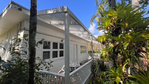 a white house with a porch and trees at Coastal Chill in Port Douglas