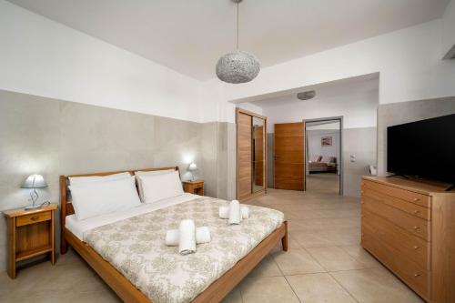 a bedroom with a bed and a flat screen tv at Villa Zafira - Seaview Manor with Heated Pool in Kallithea Rhodes