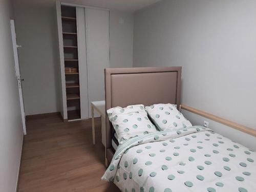 een kleine slaapkamer met een bed en een tafel bij Appartement 4 chambres 2 douches in Cergy