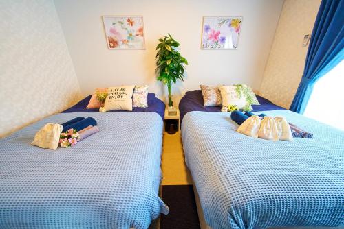 two twin beds in a room with blue sheets at Shinjuku 102 Private Stay Near Park and Station with Free WiFi in Tokyo