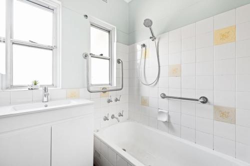 a white bathroom with a tub and a sink at Cozy Queen Room in Narwee - Next to Stations & Shops - Shared Bathroom in Riverwood