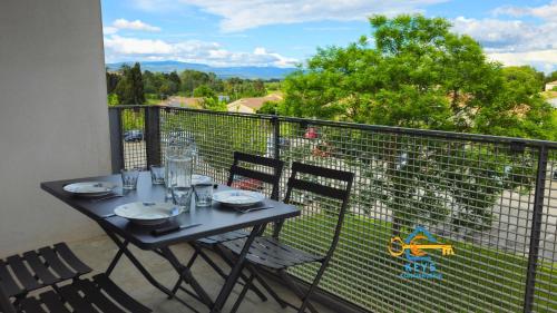 une table et des chaises sur un balcon avec vue dans l'établissement L'évasion Carcassonnais avec Terrasse 2 places de Parking privée, à Carcassonne