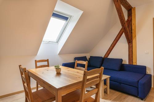 a living room with a table and a blue couch at Holy Harmony Suites in Velike Bloke