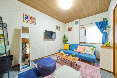 a living room with a blue couch and a table at Shinjuku 102 Private Stay Near Park and Station with Free WiFi in Tokyo