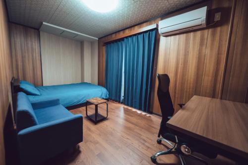 a room with a bed and a chair and a table at 唐風家 北田辺 近邻地铁 4階 in Osaka