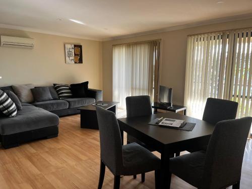 ein Wohnzimmer mit einem Tisch und einem Sofa in der Unterkunft Cowell Townhouse apartments in Cowell