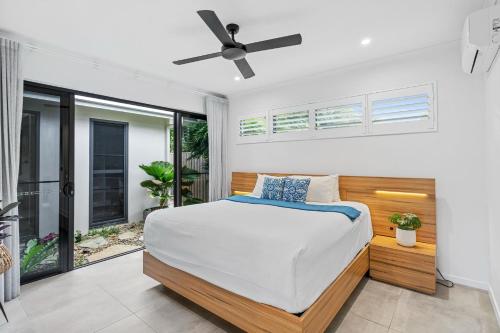 パーム・コーブにあるBelle Escapes Villabliss Palm Coveのベッドと天井扇風機のある寝室