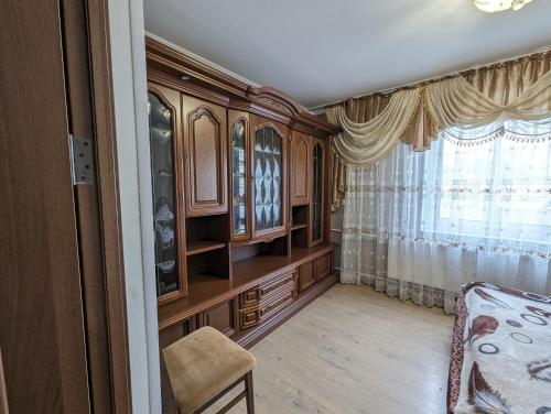 a bedroom with wooden cabinets and a window at Частный дом in Bălţi