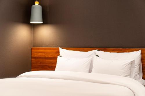 a bedroom with two beds with white sheets and pillows at Hotel May Yongsan in Seoul