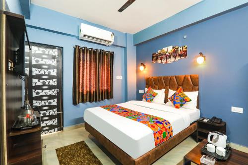 a bedroom with a large white bed and blue walls at FabHotel Dream Palace in Patna