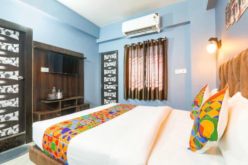 a bedroom with a white bed and blue walls at FabHotel Dream Palace in Patna