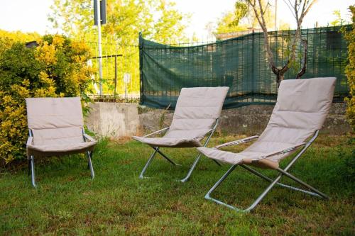 two chairs sitting in the grass in a yard at Domotic Suite at Villa Anna - Bike Friendly in Buonconvento