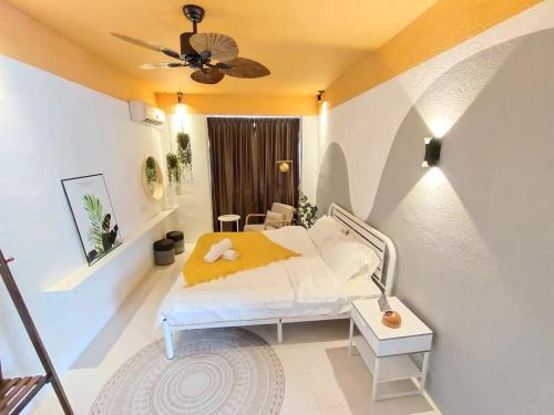 una camera da letto con un letto e un ventilatore a soffitto di Area Bandar Putra Kulai 4-6BR near AEON IOI Airport a Kulai