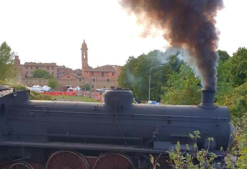 a black train is emitting black smoke at Domotic Suite at Villa Anna - Bike Friendly in Buonconvento
