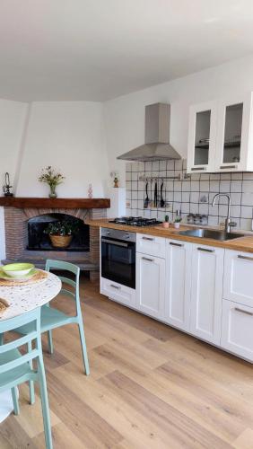 a kitchen with white cabinets and a table and a stove at Alloggio panoramico in Caprarola