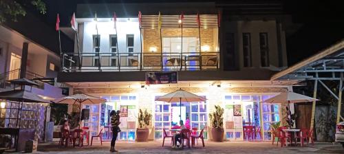 a restaurant with tables and umbrellas at night at Marietta's Hotel in Bajuyan