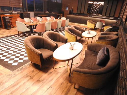 デヘラードゥーンにあるSapphire Sky Hotelの椅子とテーブル付きのレストラン