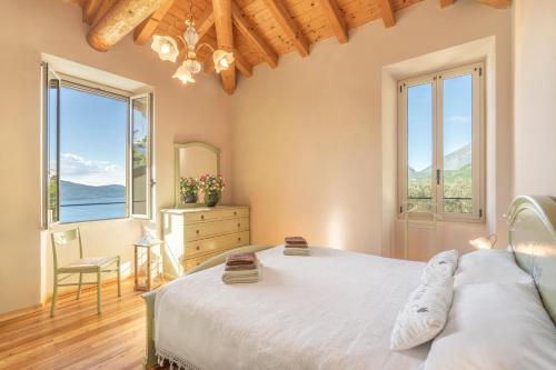 ein Schlafzimmer mit einem Bett und zwei Fenstern in der Unterkunft Piccola Meraviglia Sul Garda in Muslone