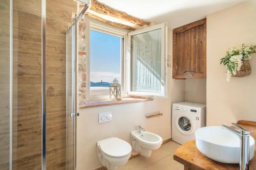 baño con lavabo y aseo y ventana en Piccola Meraviglia Sul Garda, en Muslone