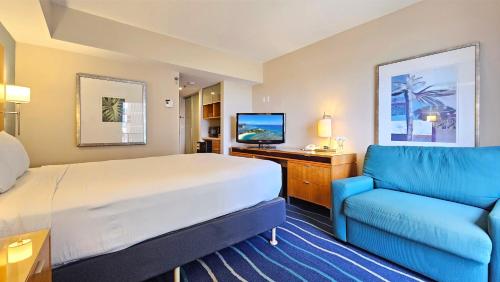 een hotelkamer met een bed en een blauwe bank bij Ocean View Room at a resort in Honolulu