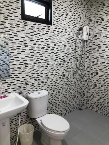 a bathroom with a toilet and a sink at หน้าวังมฤคทายวันรีสอร์ท in Ban Nong Khang