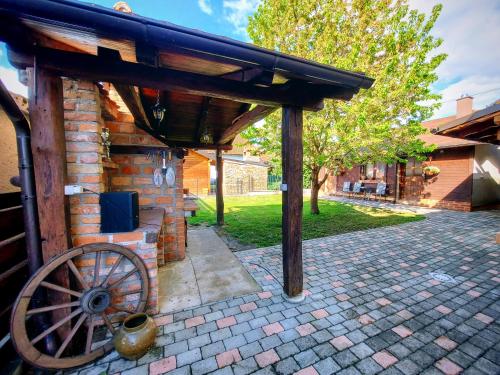 a brick building with a wooden roof and a wooden wheel at Studio apartman Buteo in Jastrebarsko