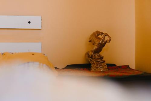 a gold statue sitting on a shelf next to a bed at Riverside • cabine in Gălăuţaş
