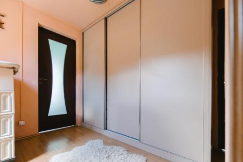 a hallway with a black door and a rug at Riverside • cabine in Gălăuţaş