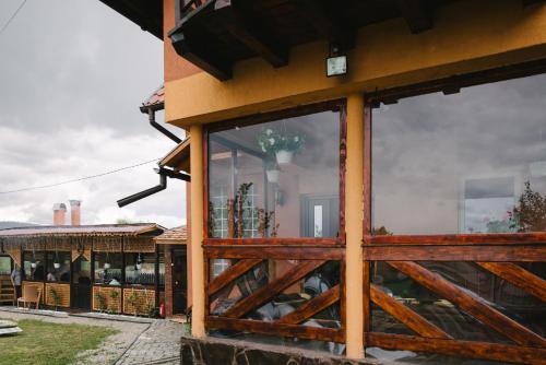a building with windows and a wooden fence at Riverside • cabine in Gălăuţaş