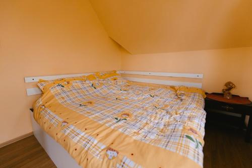 a bed with a plaid comforter in a bedroom at Riverside • cabine in Gălăuţaş