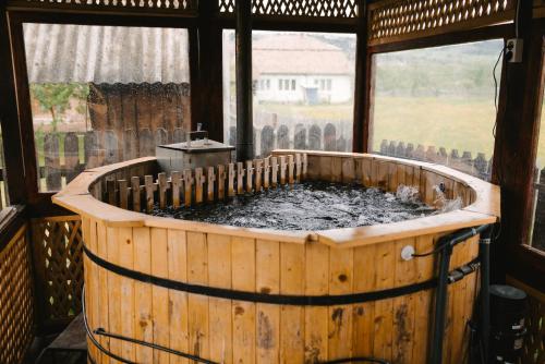 a wooden tub filled with water in a window at Riverside • cabine in Gălăuţaş