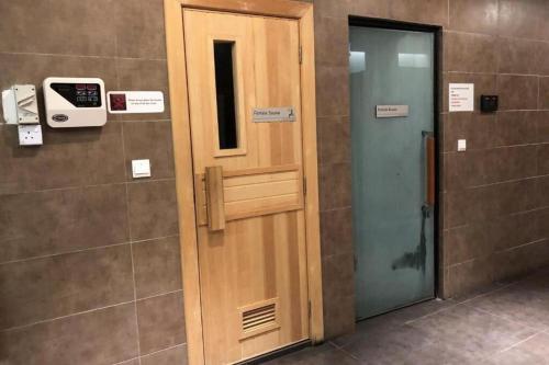 a wooden door in a bathroom with a pay phone at Silverscape Seaview Residence Melaka in Melaka