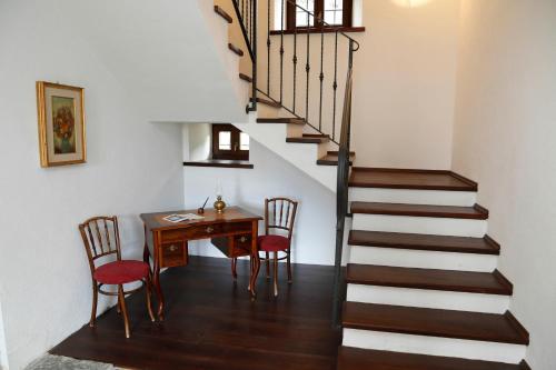 a room with a table and a staircase with a table and chairs at Cjase da Maestre in Raveo