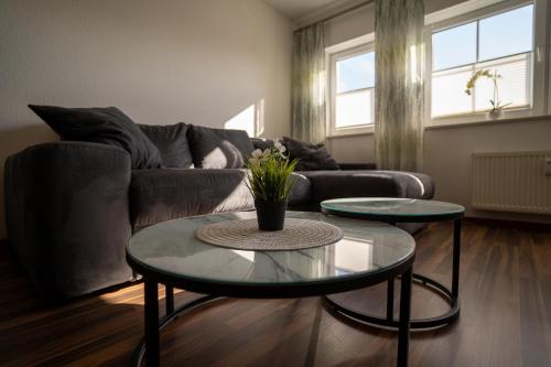 a living room with two tables and a couch at Ferienwohnungen am Geiseltalsee in Braunsbedra