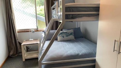 Ce lit superposé se trouve dans une petite chambre dotée de lits superposés. dans l'établissement Best Family Beach Cottage!, à Hawks Nest