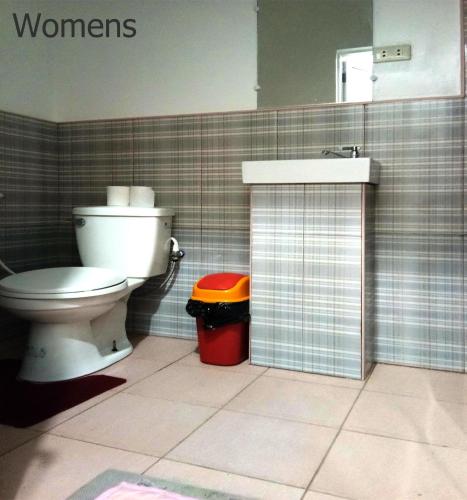 a bathroom with a toilet and a sink at Leizel's Bed & Breakfast in Palompon