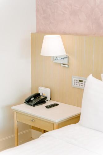 a desk with a phone and a lamp on a bed at The Sea Cret Hua Hin in Hua Hin