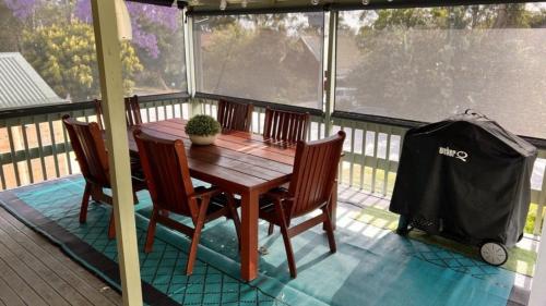 a wooden table and chairs on a screened in porch at Tropical Paradise In Ibis Av in Hawks Nest