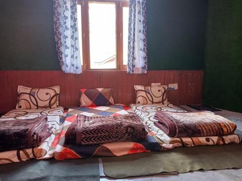 Un pat sau paturi într-o cameră la ROOP MOUNTAIN HOMESTAY