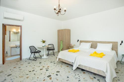 a bedroom with a bed and a table and chairs at KRANA Hotel in Líndos