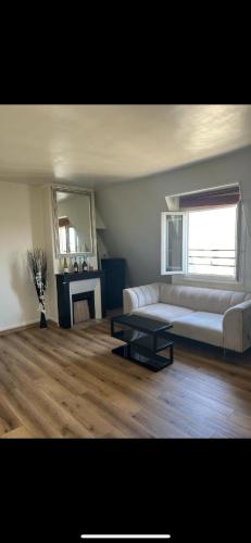 un salon avec un canapé blanc et une table dans l'établissement Magnifique appartement, à Paris
