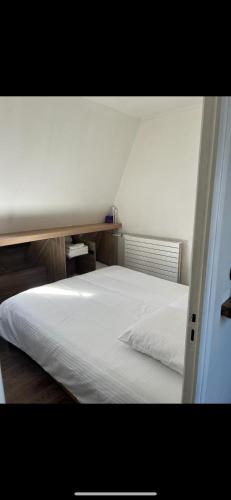 une chambre avec un lit blanc dans une pièce dans l'établissement Magnifique appartement, à Paris