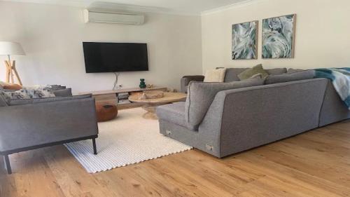 a living room with a couch and a tv at Hawks Nest's Holiday Gem in Hawks Nest