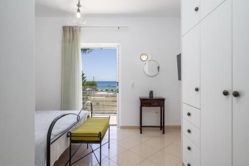 a bedroom with a bed and a view of the ocean at Beachfront Villa Alexandra in Skala Kefalonias