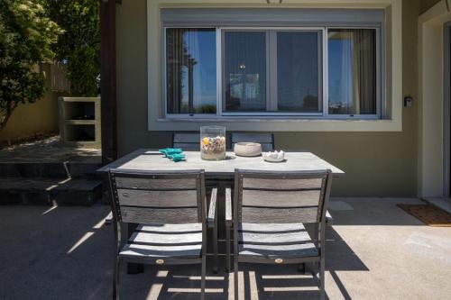 a table with two chairs sitting next to a window at Beachfront Villa Alexandra in Skala Kefalonias