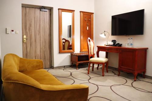 um quarto com uma secretária, uma cadeira e uma televisão em Hotel Europejski Wrocław Centrum em Breslávia